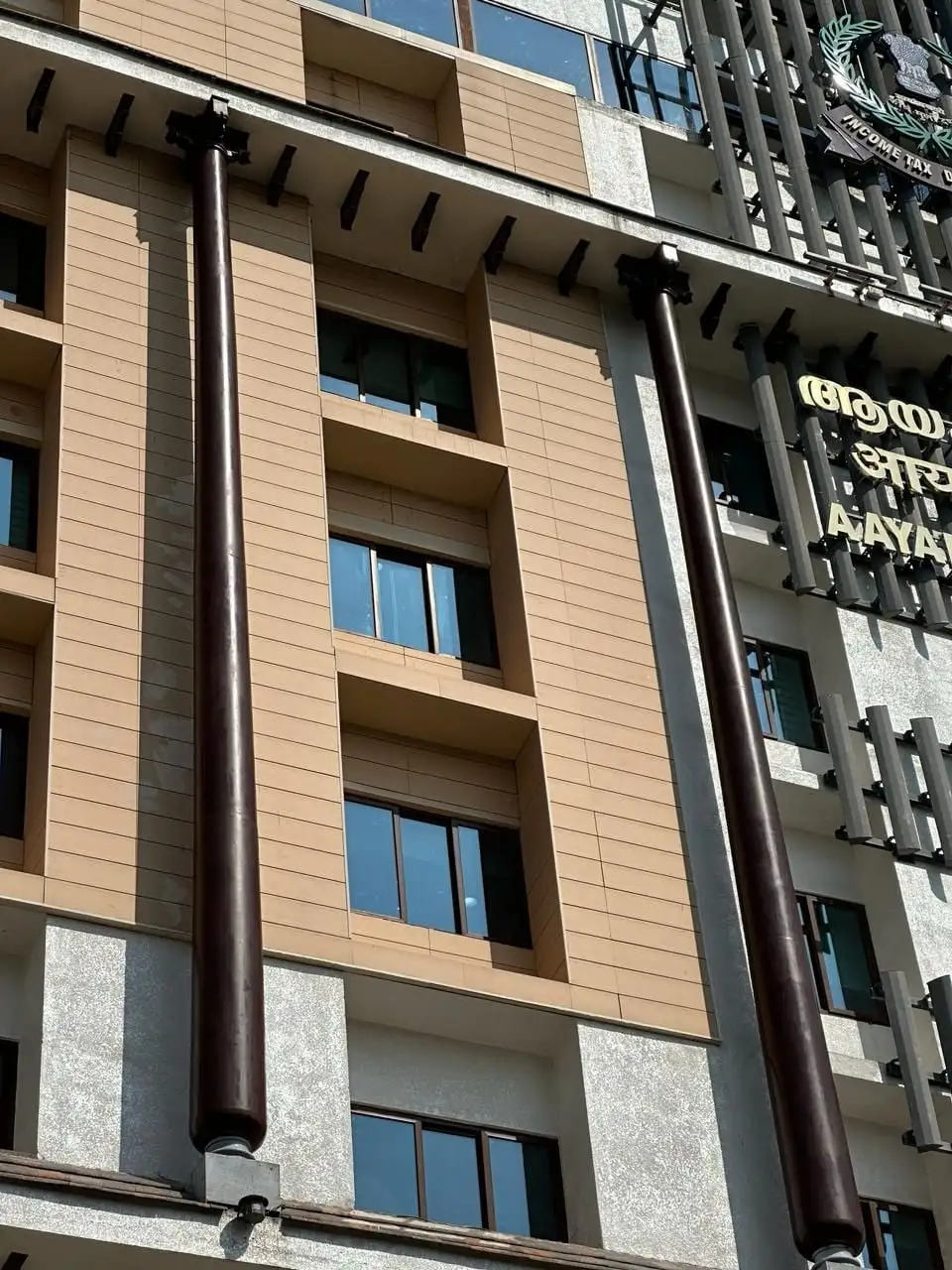 Aayakar Bhavan, Kochi, Kerala: The columns in a dark timber tone, with capitals at the top and brackets along the eaves