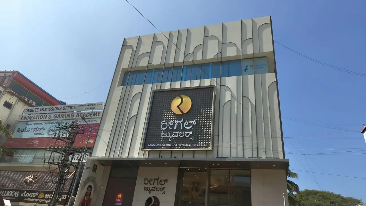 Regal Jewellers, Bengaluru: The showroom front: tall fins with curved heads, and the sign on a pyramid-textured panel