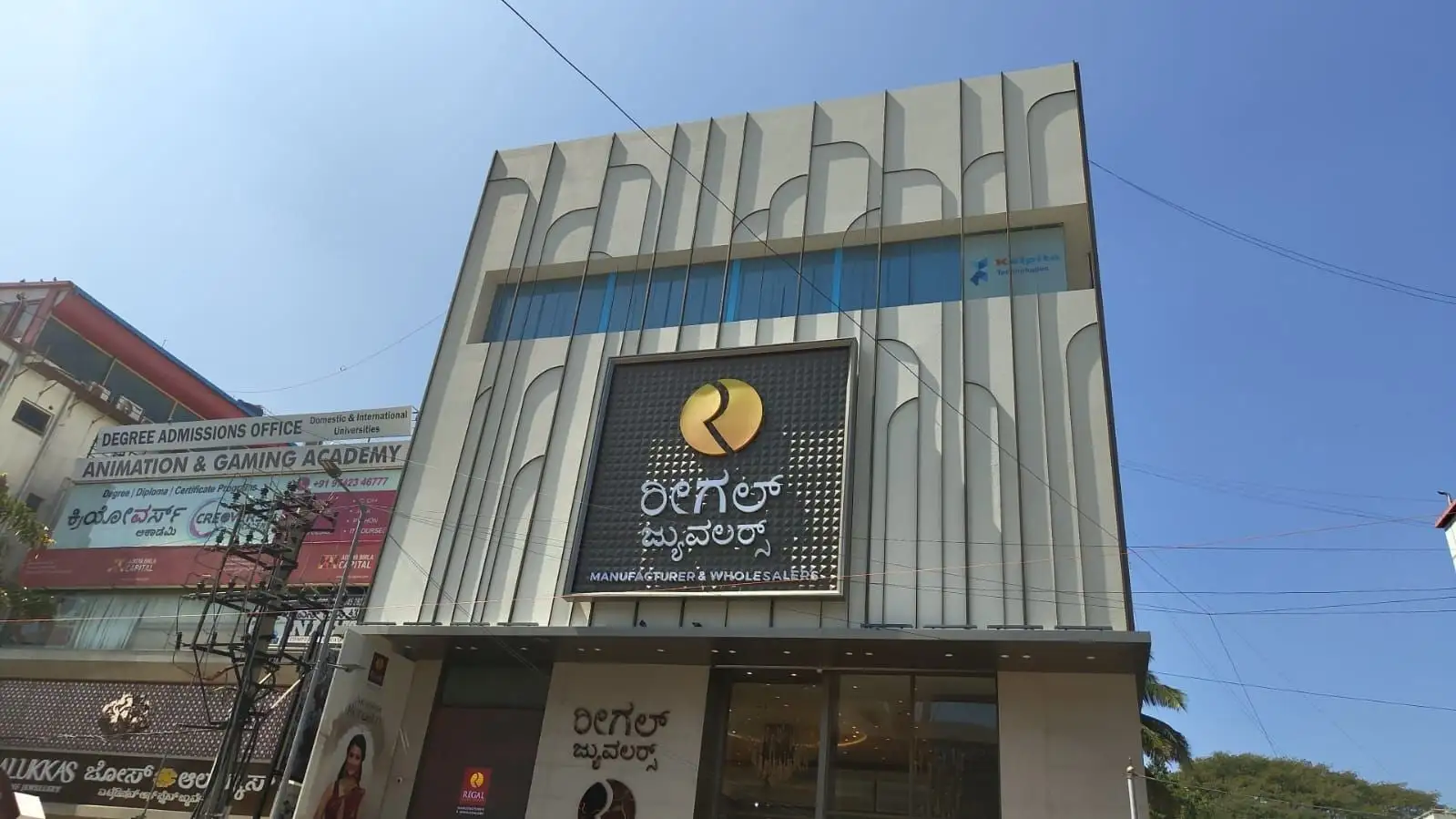 Regal Jewellers, Bengaluru: The showroom front: tall fins with curved heads, and the sign on a pyramid-textured panel