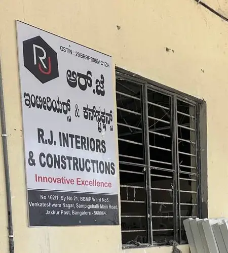 RJ Interiors & Constructions signboard in Kannada and English on the wall of the unit at Jakkur, Bangalore